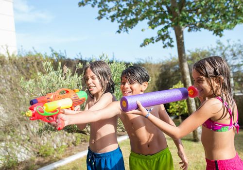 Children laughing and playing together in a group yoga session.