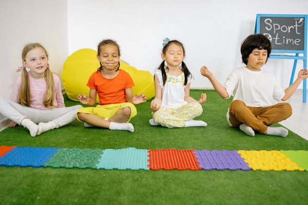Group of happy children practicing various yoga poses together.